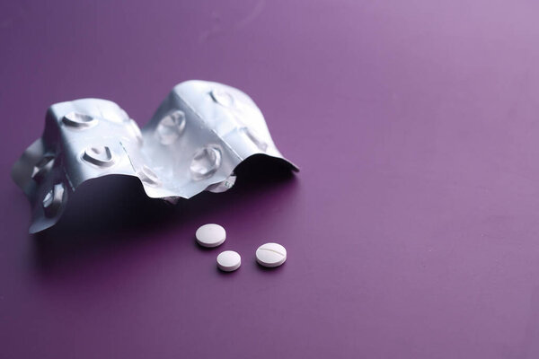 Закрытие белых таблеток и планшета на цветном фоне
 