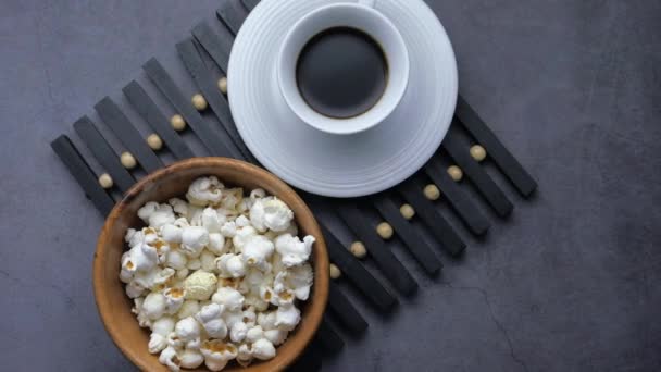 Cierre de palomitas de maíz en un tazón y té en la mesa — Vídeos de Stock