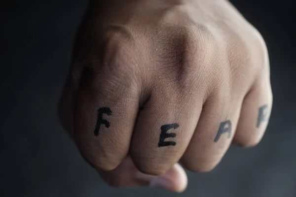 fear word written on human hand, close up