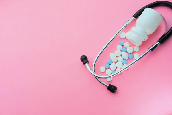 Top view av piller och stetoskop på rosa bakgrund — Stockfoto
