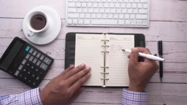 Not defterini bekleyen bir adamın üst görüntüsü 