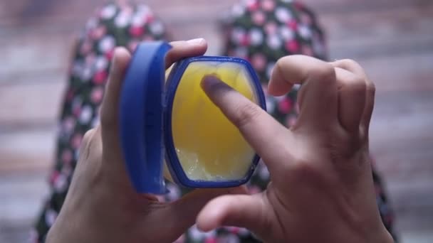 Sluiten van vrouwen gebruik petroleum jelly — Stockvideo