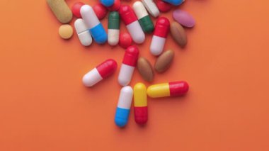 Pembe arka planda hapların ve kapsülün üst görünümü 