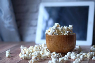 Tabaktaki patlamış mısırı ve masadaki dijital tableti kapat. 