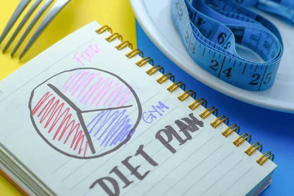 Dieet plan geschreven op notitieblok op kleur achtergrond — Stockfoto