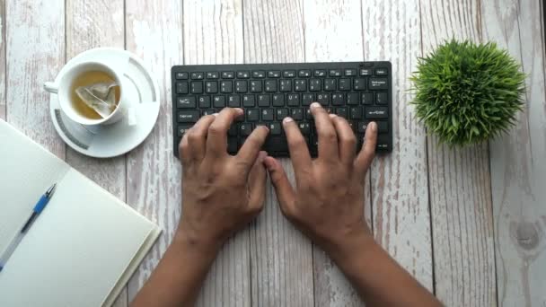 Vista superior del hombre escribiendo a mano en el teclado en la mesa de la oficina — Vídeos de Stock