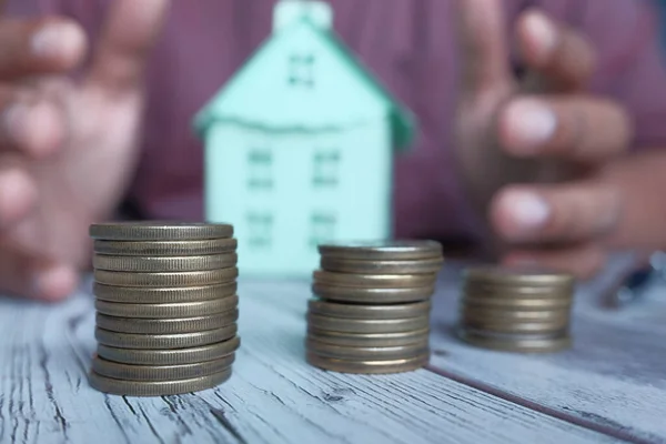 Conceito de finanças em casa com moeda e casa na mesa — Fotografia de Stock