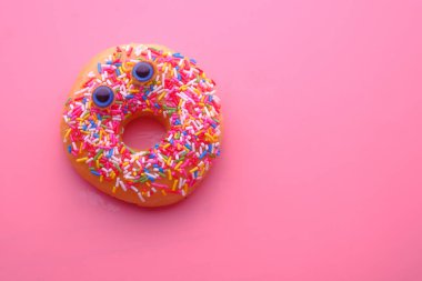 Renkli arka planda komik suratlı donutları kapat .