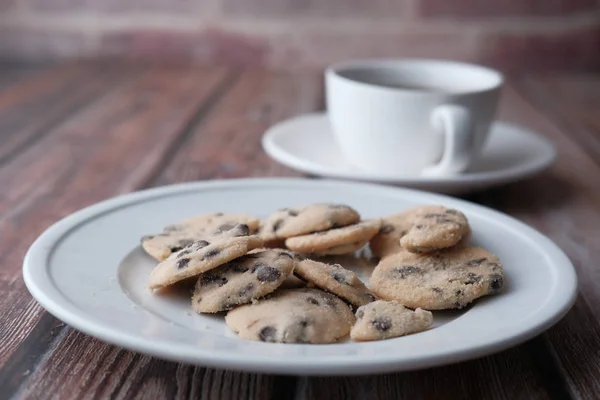 Cierre de galletas en el plato y té en la mesa — Foto de Stock