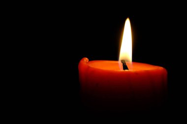 Close up of burning colorful candle at night, praying 