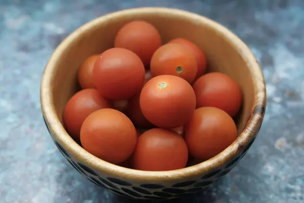 Close up de tomate cereja em uma tigela na mesa — Fotografia de Stock