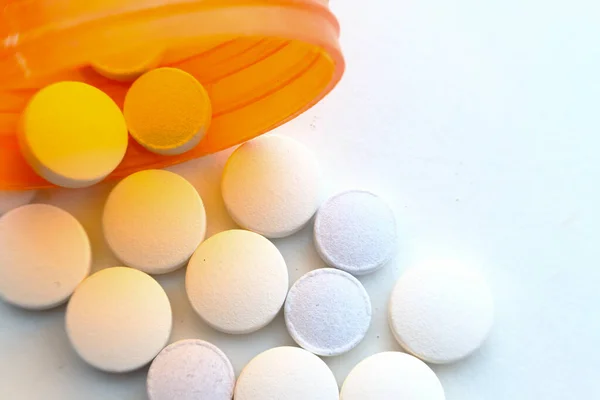 Крупный план разлива белых таблеток из контейнера — стоковое фото