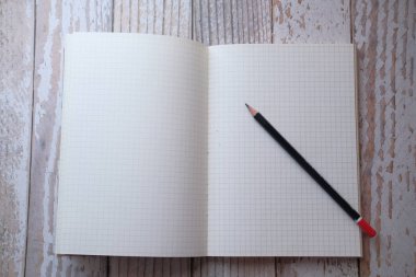 Masadaki not defteri ve kalemlerin üst görünümü 