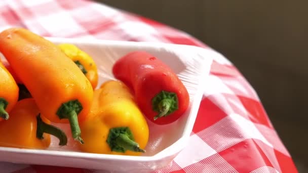 Close up of red a yellow pepper on table — Stock video