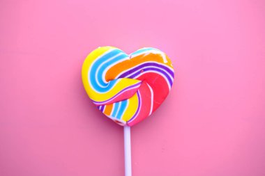 Pembe arka planda kalp şeklinde şeker 