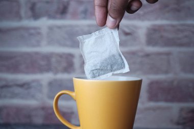 Sabahları sıcak su bardağına piramit çay poşeti koyuyorsun.