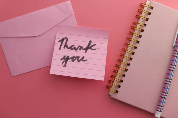 Primer plano de nota de agradecimiento y sobre sobre fondo rosa — Foto de Stock