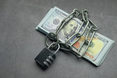 Katlanmış dolar banknotları asma kilitli metal zincir ile bağlanmış. İş konsepti.
