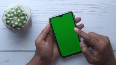 Erkek elinin üst görüntüsü Masada akıllı telefon kullan 