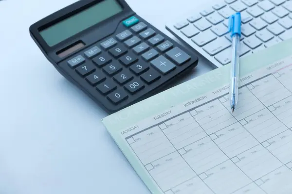 Primer plano del planificador, pluma y calculadora en la mesa — Foto de Stock