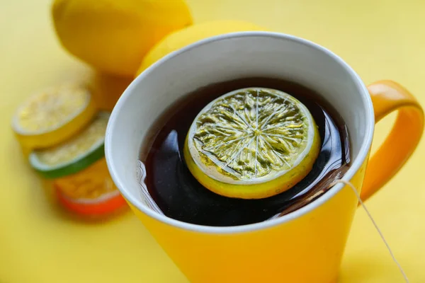 Primer plano de té de limón sobre fondo amarillo —  Fotos de Stock