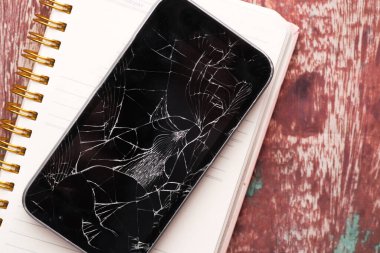 Beyaz arkaplandaki bozuk akıllı telefonun üst görünümü 