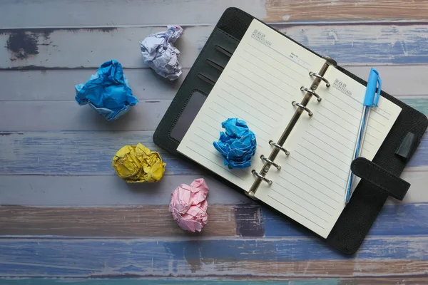 Top view of crumbled paper ball and notepad on table — Stock Photo, Image