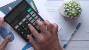 top view of man hand use calculator on office desk