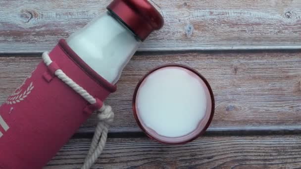 Top view of glass of milk and milk bottle on table — Stock Video