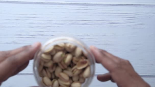 Vista superior de los pistachos en un frasco sobre la mesa — Vídeos de Stock