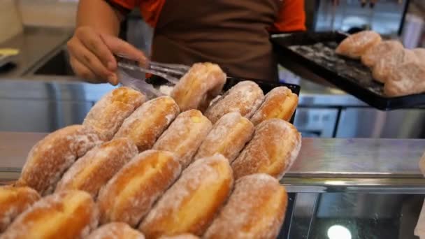 Primer plano de la exhibición de rosquillas frescas horneadas para la venta — Vídeos de Stock