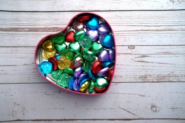 Kalp şeklindeki şekerlemelerin en üst görüntüsü masadaki hediye kutusunda, sevgililer gününde. 