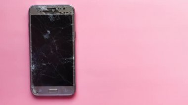 Pembe arkaplandaki bozuk akıllı telefonun üst görünümü 