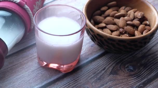 Закрыть свежий миндаль и молоко на столе — стоковое видео