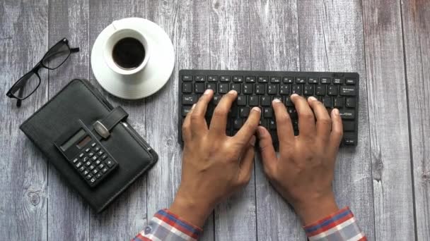 Vista dall'alto dell'uomo digitando a mano sulla tastiera sul tavolo dell'ufficio — Video Stock