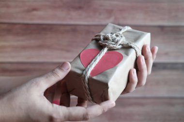 Kadınların el ele tutuştuğu hediye kutusunu kapatın.