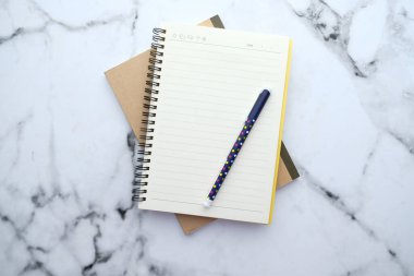 Masadaki not defteri ve kalemin üst görünümü 