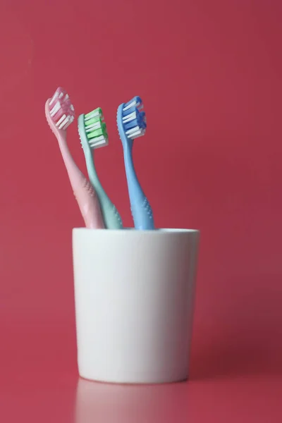 Toothbrush in a glass on a red background — Stock Photo, Image