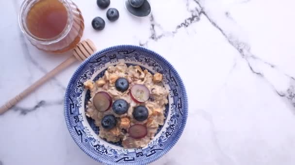 Blaubeeren auf Hafer und Honig auf dem Tisch — Stockvideo