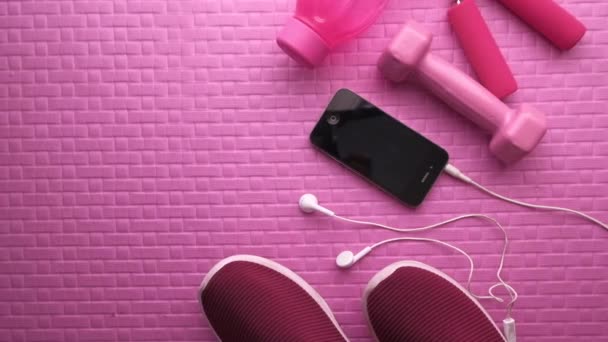 Flat lay com equipamento desportivo e telefone inteligente em fundo rosa — Vídeo de Stock