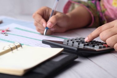 young women hand use calculator and notepad on desk