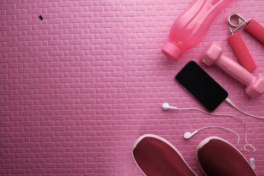 Yoga minderi, akıllı telefon, ayakkabı ve dambıl..