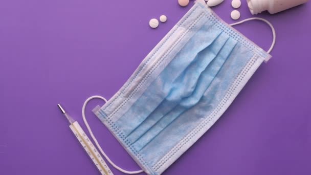 Top view of face mask, pills and thermometer on table. — Stock Video