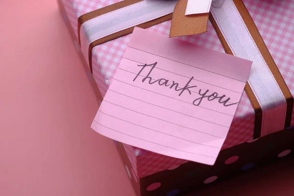thank you message on gift box on pink background