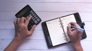 İnsan elinin üst görünümü ofis masasında hesap makinesi 