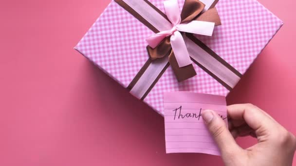 Спасибо сообщение на подарочной коробке на розовом фоне — стоковое видео