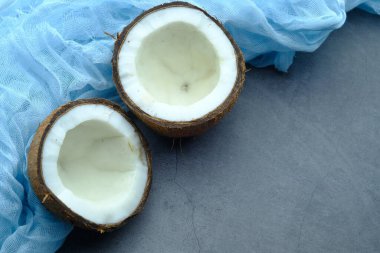 Siyah arkaplanda yaprakları olan hindistan cevizinin yarısı