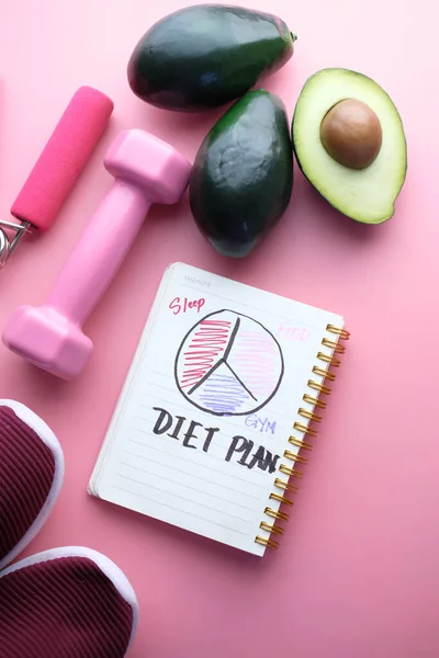 Notebook met een dieet plan met verse avocado en halter — Stockfoto