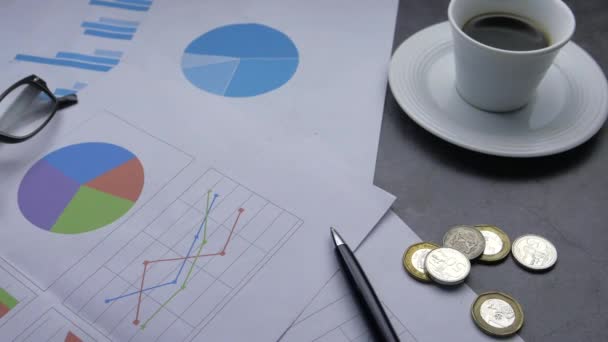 Крупним планом фінансовий графік і ручка на столі — стокове відео