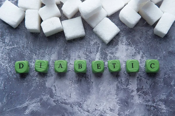 Bloedsuikermeting voor diabetes, suikerklontje en houten tekst — Stockfoto